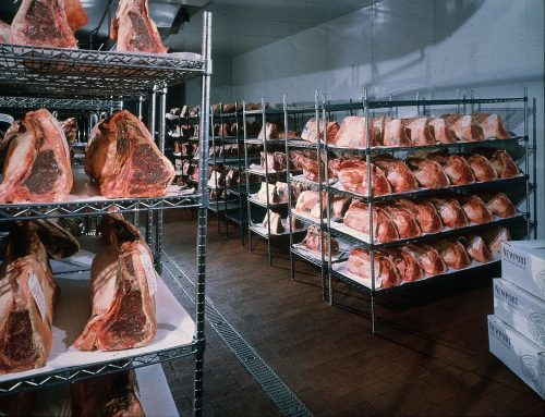 An image of beef on open air racks during the dry aging process